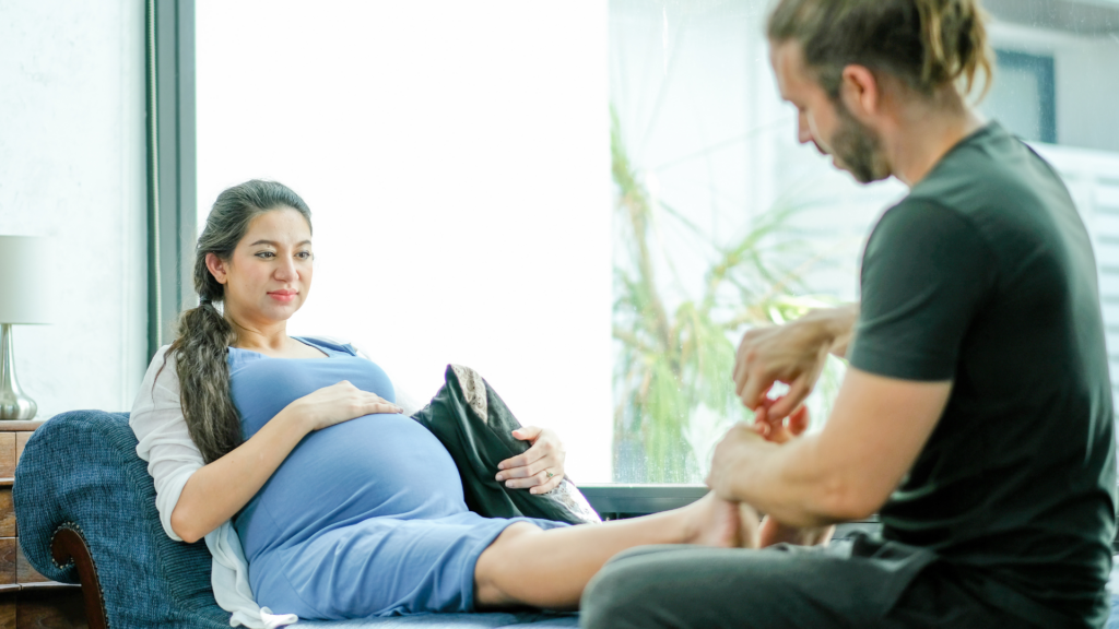 une femme bénéficiant d'une séance de réflexologie plantaire pendant sa grossesse
